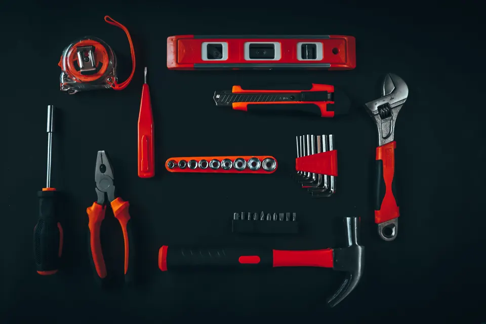 Household repair tools arranged on a dark surface